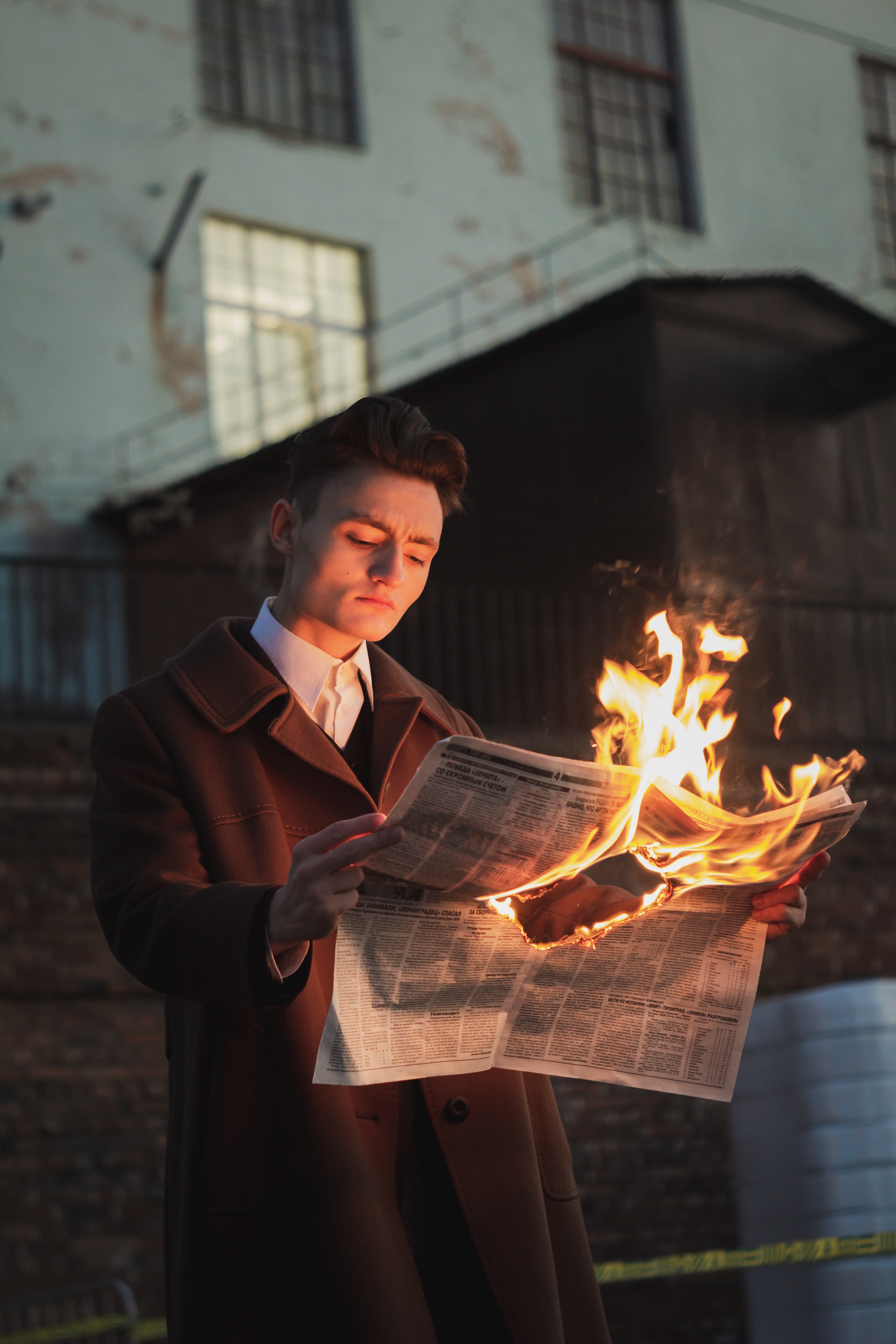 Picture of a man reading a burning newspaper.